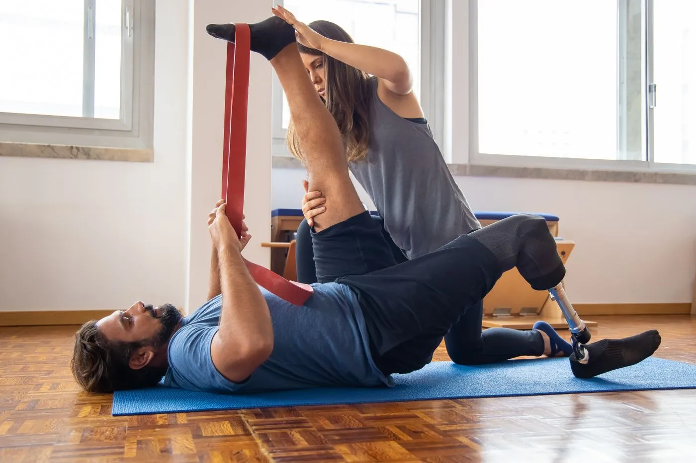A patient working through a resistance band exercise on the mat