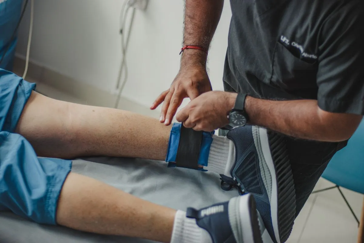 A physical therapist fitting a support to a runner's ankle